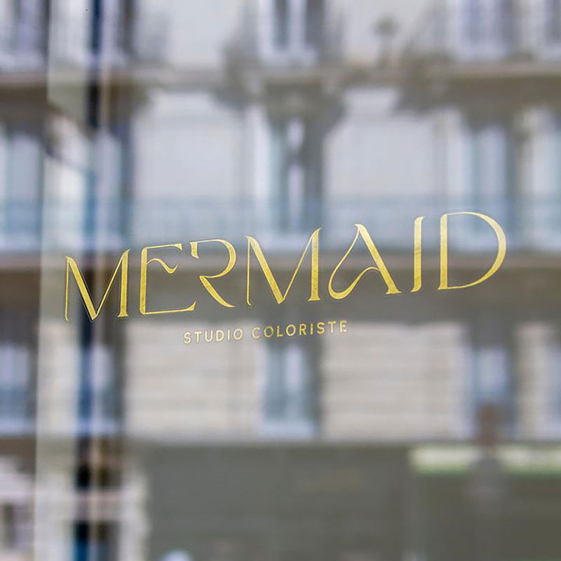 Logo sur la vitrine du salon de coiffure Mermaid à Nantes réalisé par l'agence de communication EB à Nantes (44200)